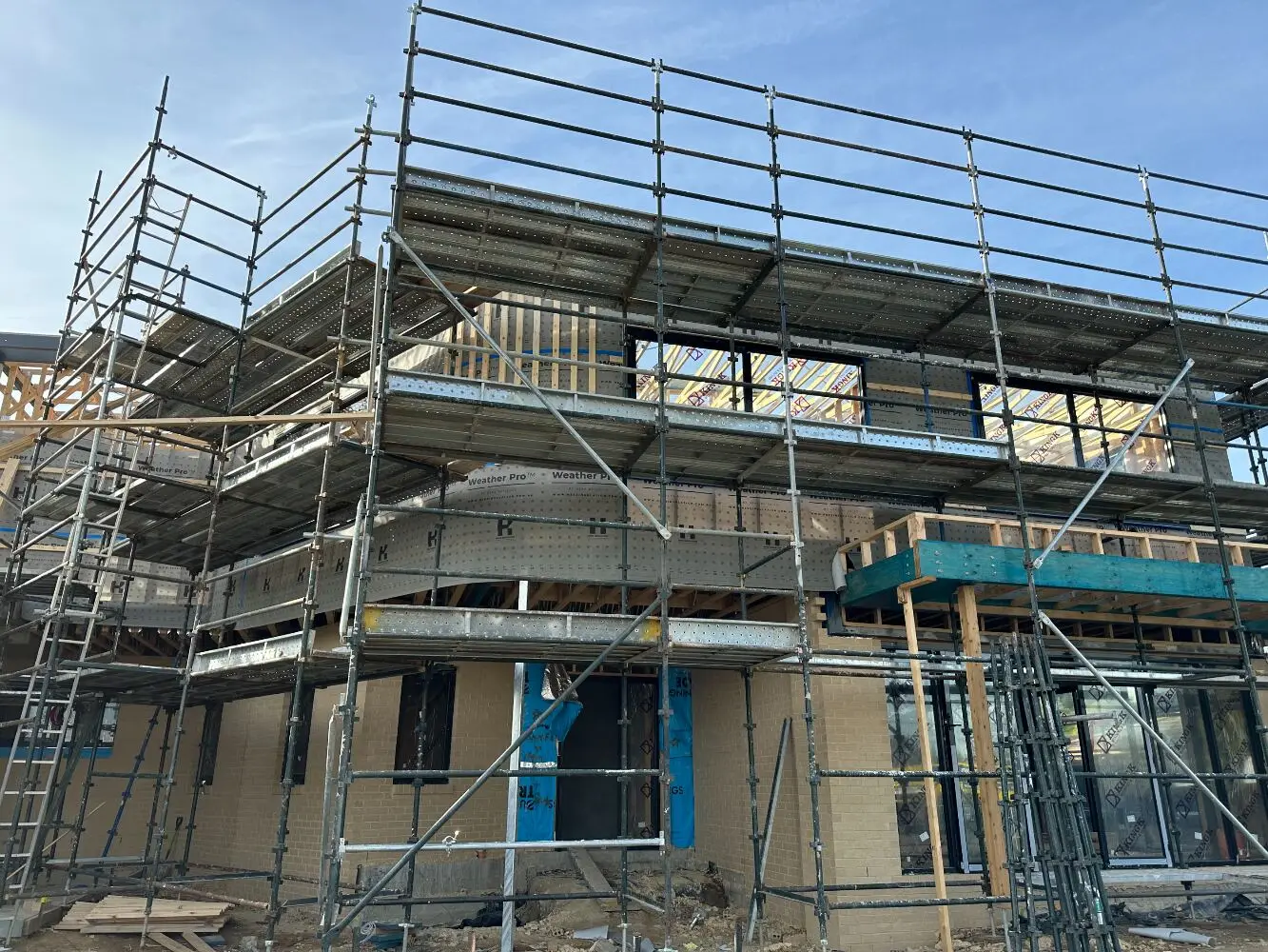 Multi-storey building under construction behind scaffolding