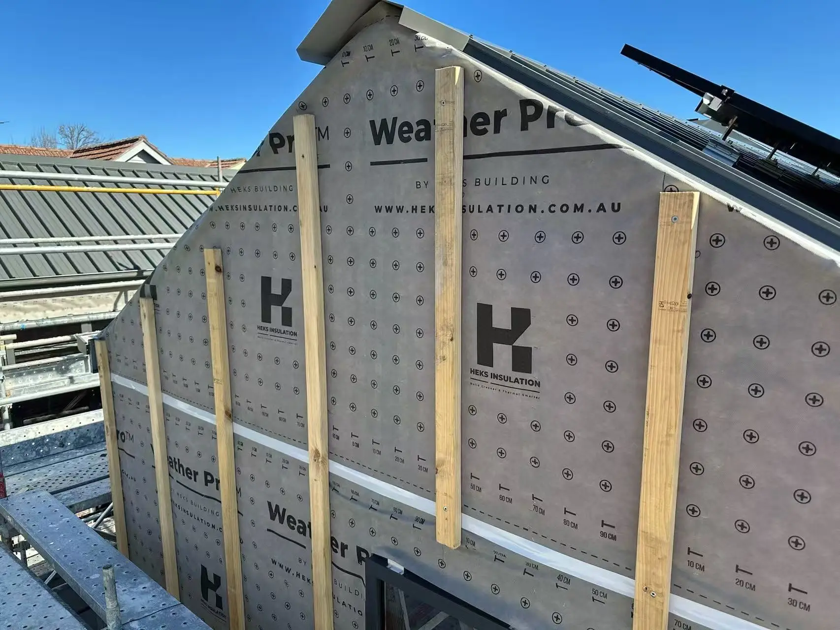 House frame covered in HEKS-branded wall wrap
